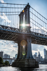 Manhattan Bridge NYC z rozbłyskiem słońca przez most