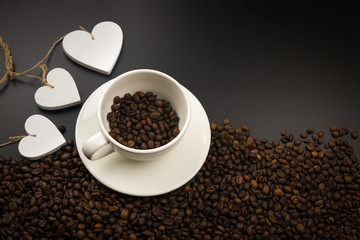 Filiżanka kawy pełne ziarna kawy z trzema białymi sercami