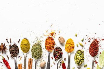 Zestaw różnych przypraw w łyżki na białym tle
