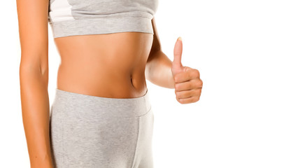 seksowny szczupły brzuch kobiety i kciuki do góry na białym tle