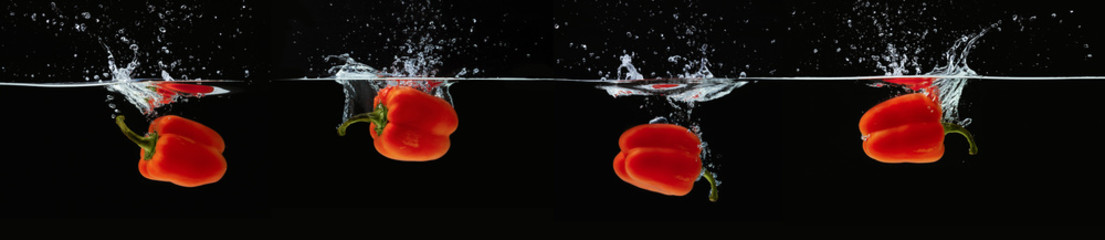 Barwiona pomarańczowa papryka w wodzie bryzga na czarnym tle
