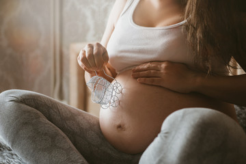 Biały wózek na brzuchu w ciąży