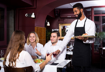 Restauracja średniej klasy i wesoły kelner