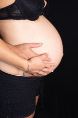brzuch kobiety w ciąży z ojcem mężczyzna i kobieta ręce matki na czarnym tle w koncepcji zdrowej ciąży