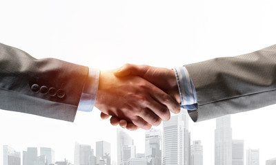 Biznesowy uścisk dłoni jako pomysł na jedność i współpracę lub powitanie. Różne środki przekazu