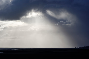 Sylwetka wioski Saint Valery sur Somme i burzliwe niebo w zatoce Somme