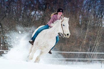 blondynka młoda kobieta jedzie jej konia przez śnieg oklep w zimowy dzień