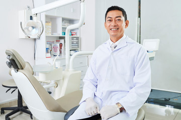 Male doctor sitting in stomatological cabinet