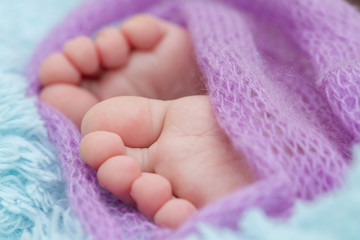 Dziecięce nogi w fioletowej narzutce.