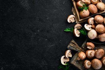 Pieczarki na czarnym kamiennym tle. Widok z góry Pieczarki. Wolna przestrzeń do kopiowania.