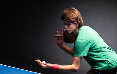 Chłopiec gra w ping ponga w tenisa stołowego