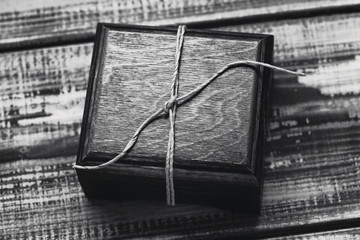 Drewniane pudełko na prezent. Drewniane pudełko z prezentem na drewniane tło zbliżenie. Czarno-białe zdjęcie