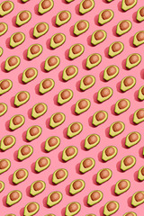 Kolorowy owoc wzór świeże cutted avocado połówki z jamami na korala menchii tle, odgórny widok