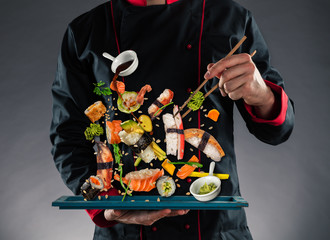 Mistrz kuchni trzyma pałeczki z latającym sushi