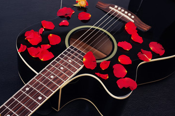 Gitara akustyczna i czerwone płatki róż