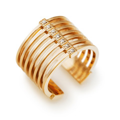 Złoty pierścionek z małymi kamieniami odizolowywającymi na białym tle