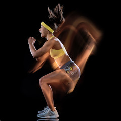 jedna kobieta mieszanej rasy ćwiczeń fitness wyizolowanych na czarnym tle z efektem lightpainting