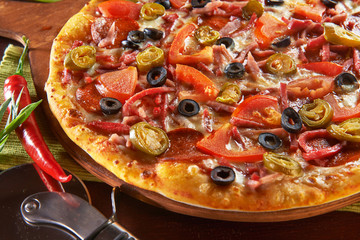 Świeża pizza na drewnianym stole z składnikami