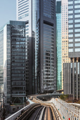 Widok nowoczesnych drapaczy chmur i linii kolejowej Yurikamome w Tokio, Japonia. Pejzaż pionowy.