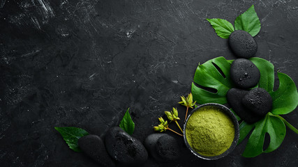 Zen kamienie i liście z kropli wody. Zdroju tło z zdrojów akcesoriami na ciemnym tle. Widok z góry. Wolne miejsce na Twój tekst.