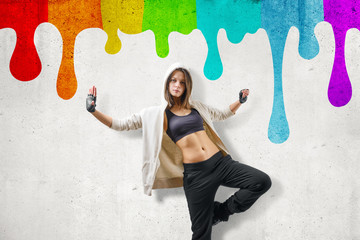 Street dance młoda dziewczyna tańczy na tle kolorowe ściany tęczy