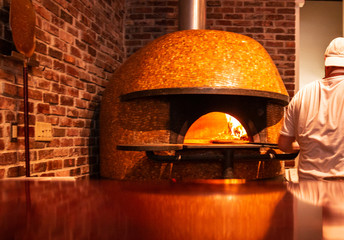 Pizzę wkłada się do ognistego pieca ceglanego