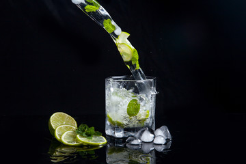 Lato koktajl mojito z splash na czarnym tle .. \ t