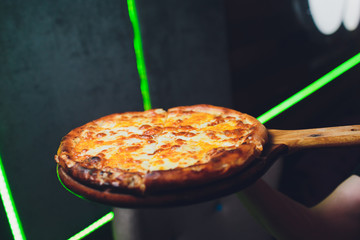 Parująca gorąca smaczna margarita Włoska pizza świeża z pieca do pizzy w pizzerii serwowana na długiej desce z drewnianą deską z copyspace.
