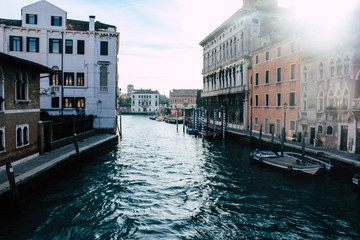 Widok na kanał wenecki, gondole i łódź na wodzie. Malowniczy widok na panoramę Wenecji w zimie.