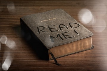 Holy Bible book with read me letters on a wooden background