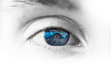 kobiece oko z odbiciem samochodu w oku, abstrakcja jazdy i podróży