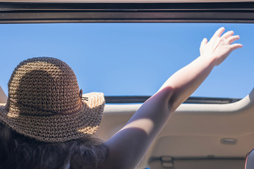 girl driver traveling by car and holds her hand out from open hatch of a vehicle. Travel lifestyle concept