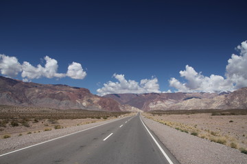 prosta droga asfaltowa i góry andy daleko w tle w soneczny dzień