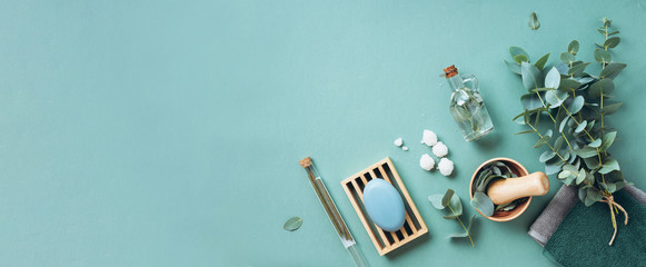 Mydło, eukaliptus, ręczniki, szczotka do masażu, sól, olejek aromatyczny i inne obiekty spa na zielonym tle. 