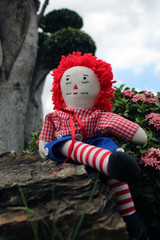 raggedy Anne doll sitting outside, Old Time Rag Doll, Ghost mystic doll. Scary horror doll