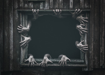 Hands rising out from the old window ancient house, Halloween concept. Increased noise and grain effect.