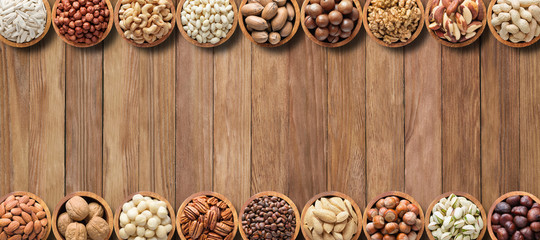 various nuts and seeds on wooden table with copy space. healthy food background