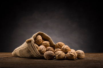 walnuts in jute bag on wooden table