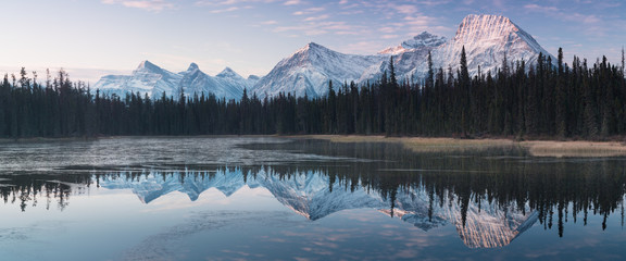 Prawie prawie doskonałe odbicie Gór Skalistych w Bow River. Blisko Canmore, Alberta, Kanada. Zbliża się sezon zimowy. Kraj niedźwiedzia. Koncepcja piękny krajobraz tło.