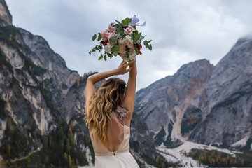 Woman holding bouquet in mountains