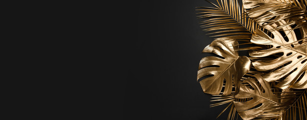 Liście palmowe malowane na złoto na czarnym tle