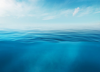 Blue sea or ocean water surface and underwater with sunny and cloudy sky