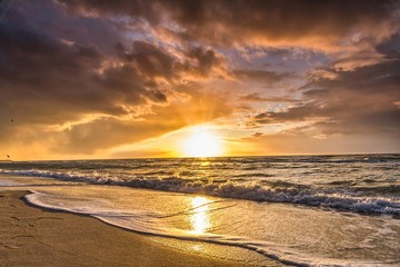 kolorowy zachód słońca z zachmurzeniem nad zachodem słońca na plaży.
