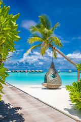 Tropical beach background as summer landscape with beach swing or hammock and white sand and calm sea for beach banner. Perfect beach scene vacation and summer holiday concept. Boost up color process