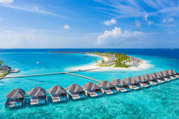 Perfect aerial landscape, luxury tropical resort or hotel with water villas and beautiful beach scenery. Amazing bird eyes view in Maldives, landscape seascape aerial view over a Maldives