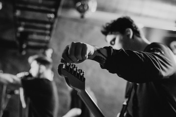 Man on the stage tuning his guitar