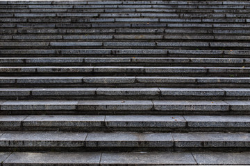 Granitowe duże schody, ciemne tło.
