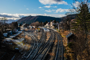 A picturesque view of several railroad tracks leading to the railway station of a town in the French Alps on a cloudy day in winter (Veynes, Hautes-Alpes, France)