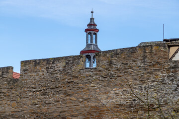 Part of the historic city wall with bell tower in the background in Meisenheim