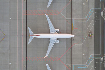 Top down view on comercial airplane in the parking lot of the airport apron, waiting for services maintenance, refilling fuel services after airspace lock down